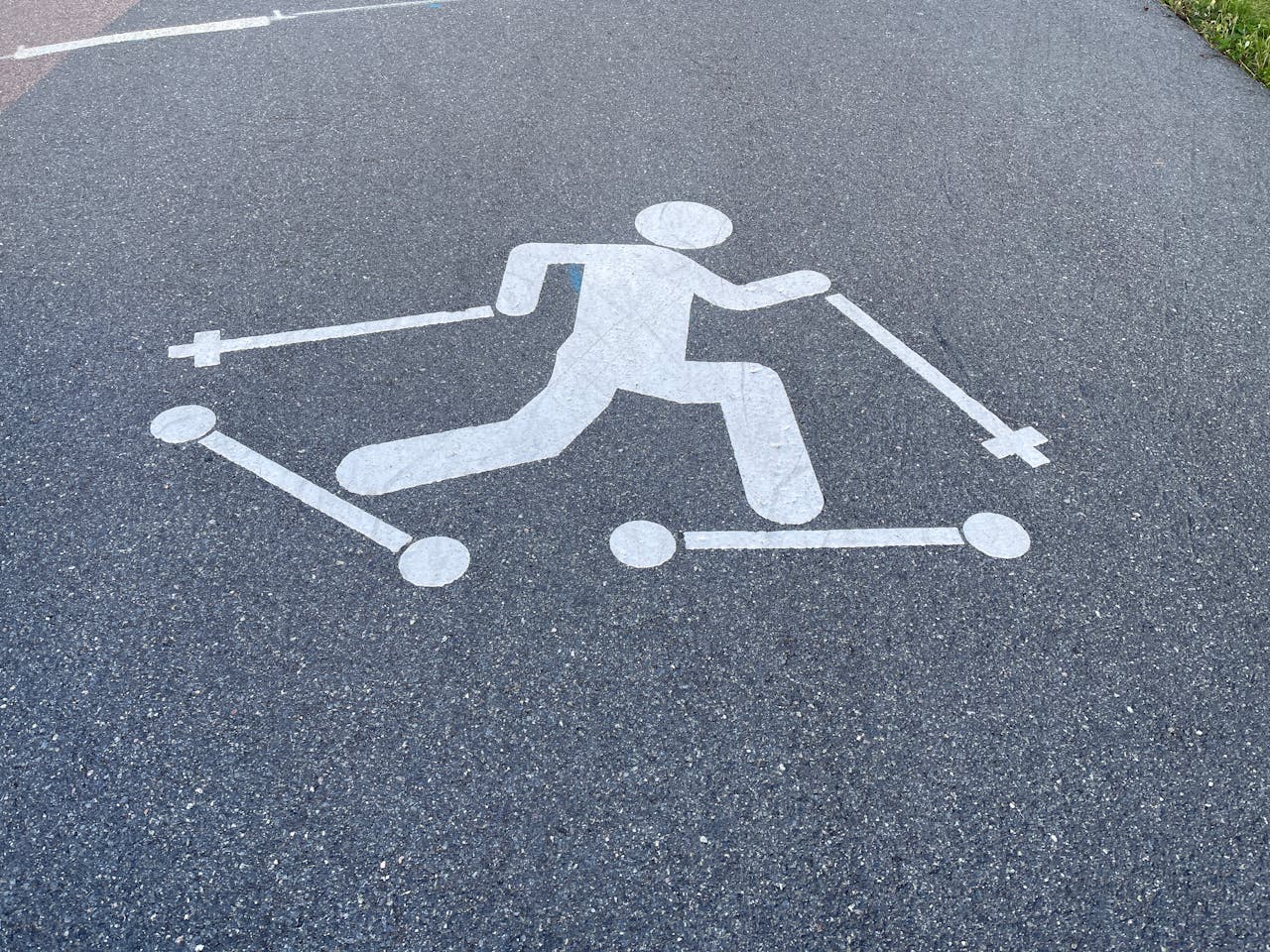 A pedestrian symbol painted on a pathway in Oslo, Norway indicating skiing activity.