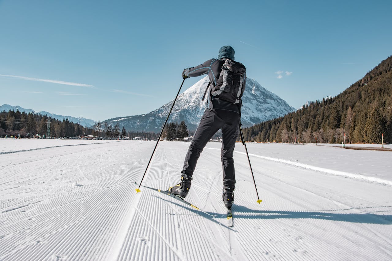 Skier enjoying cross-country skiing in beautiful Tirol, Austria, framed by snowy mountains.